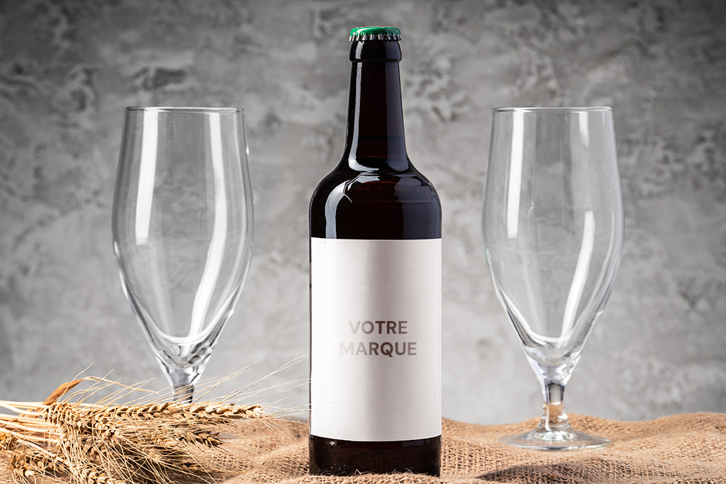 bouteille de bière en marque blanche entre deux verre à bière blonde