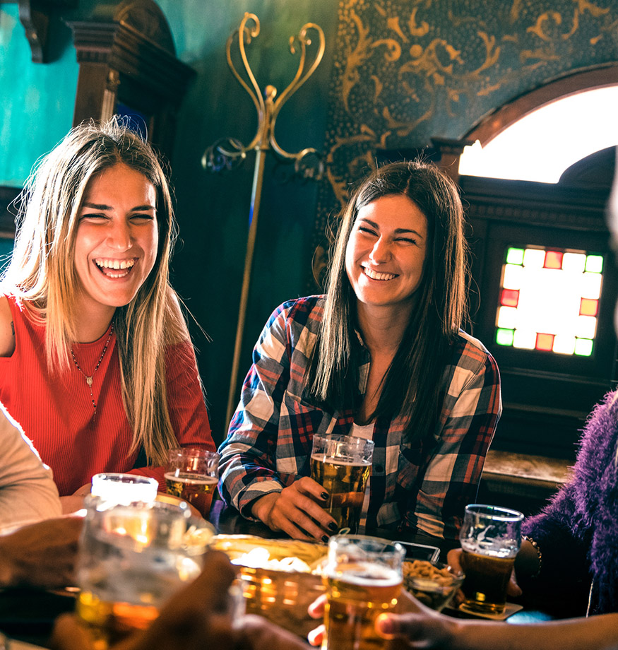 groupe d'amis heureux dégustant une bière autour d'une table dans une brasserie